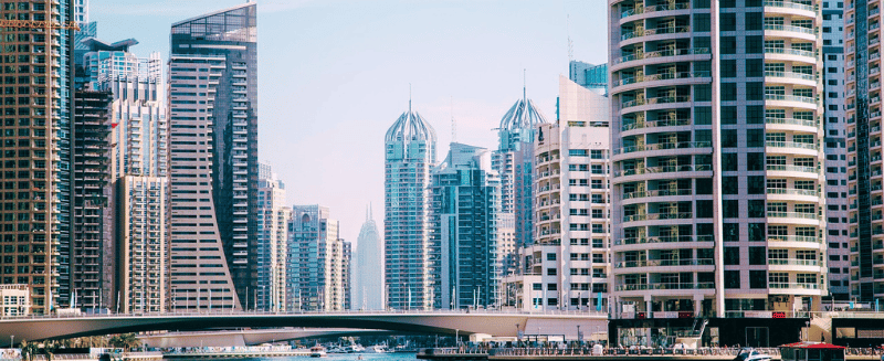 Modern skyline of Dubai Marina with high-rise towers and a bridge over the water, representing WIUS Capital’s global financial base and connection to international private credit markets.