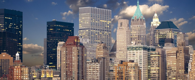 US city skyline at dusk reflecting regional economic hubs that support demand in US housing investment fundamentals.