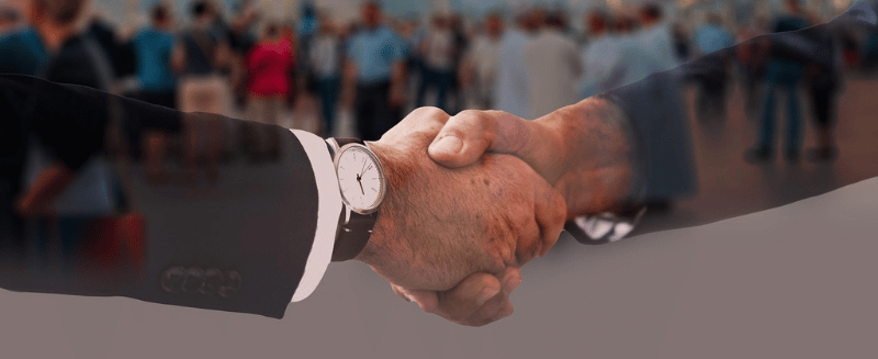 Business handshake symbolising mid-market acquisitions and structured agreements within global M&A investments.