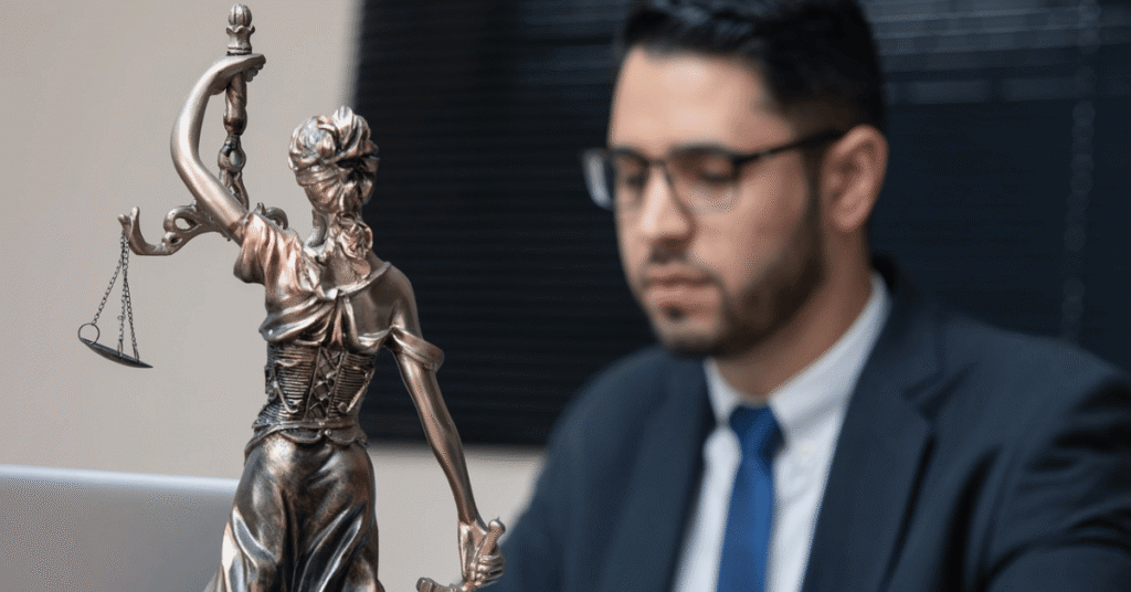 Lady Justice statue beside a desk with a professional reviewing documents, representing structure and risk review in litigation funding loan notes.