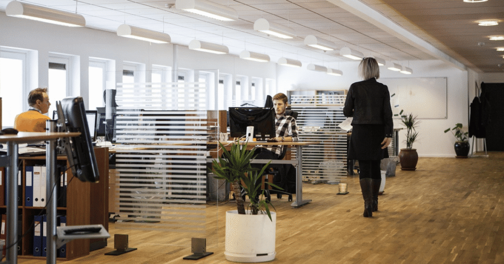Modern open-plan office with professionals at work, representing operational performance, management oversight, and post-acquisition execution in global M&A.