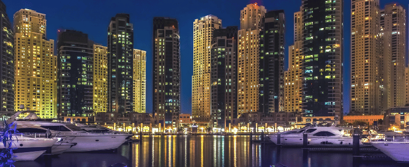 Luxury waterfront skyline featuring modern high-rise developments and marina facilities in Dubai, representing global investment opportunities, private markets, and alternative asset diversification for sophisticated investors.